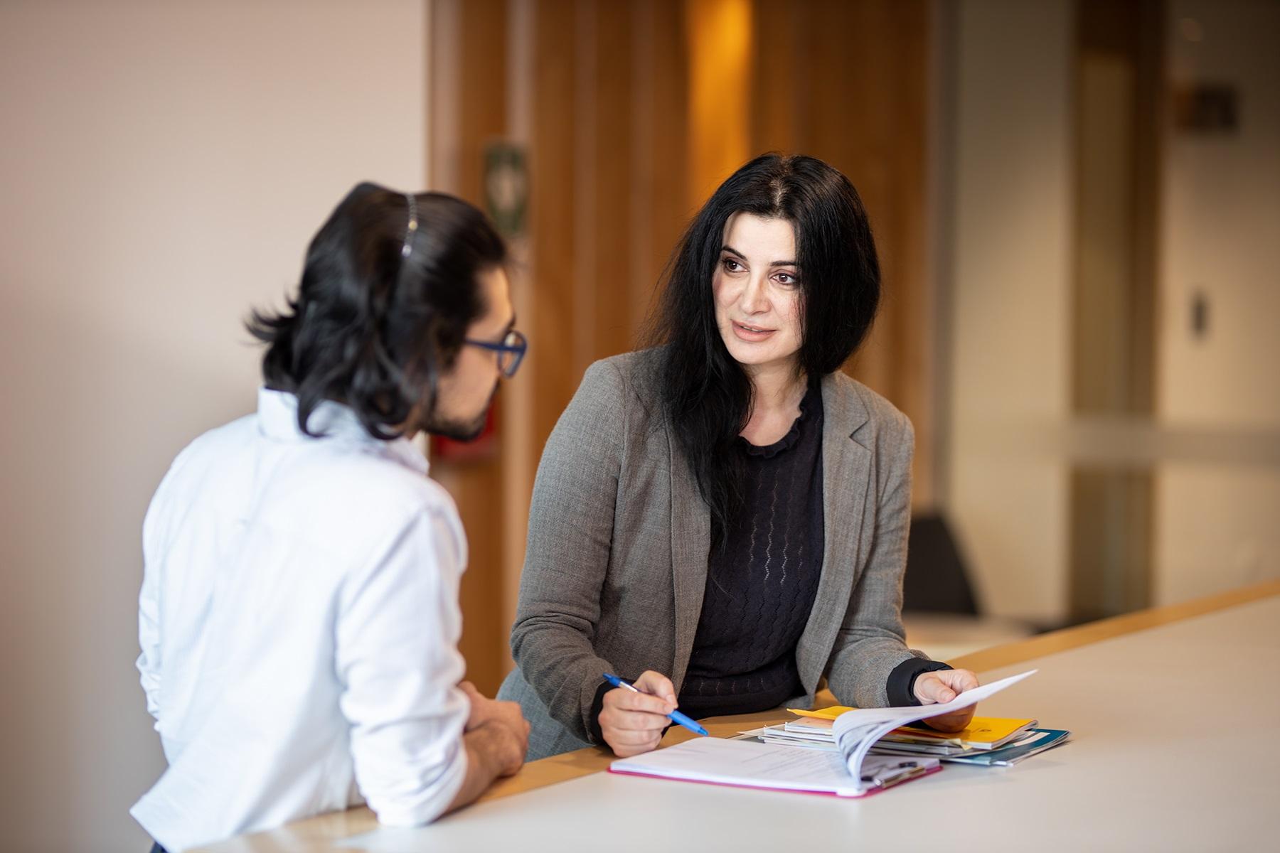 Photo of a female SBDC business adviser providing advice to a man who is looking to start a business.
