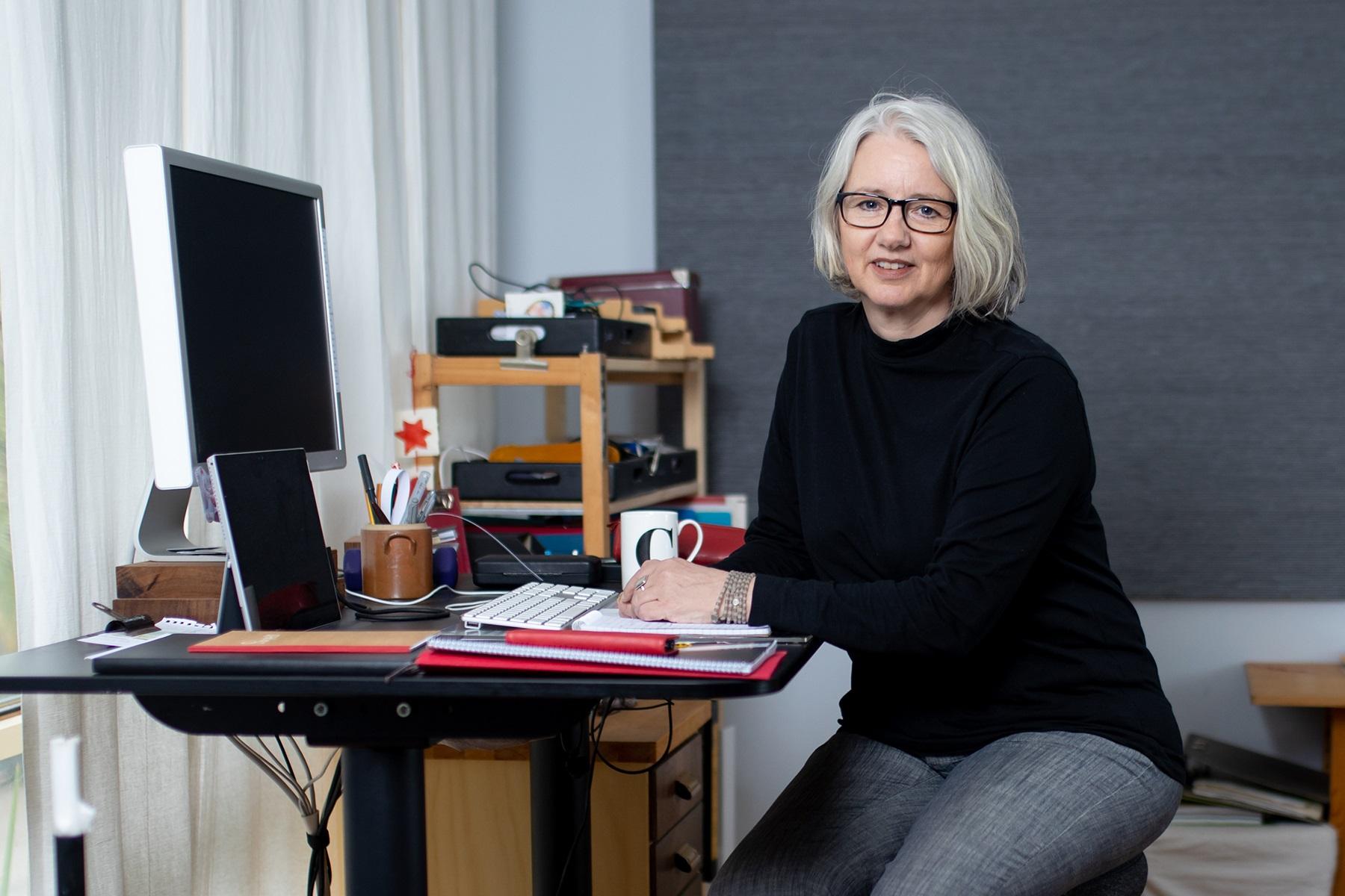 Photo of a woman sitting at the desk of her home office.