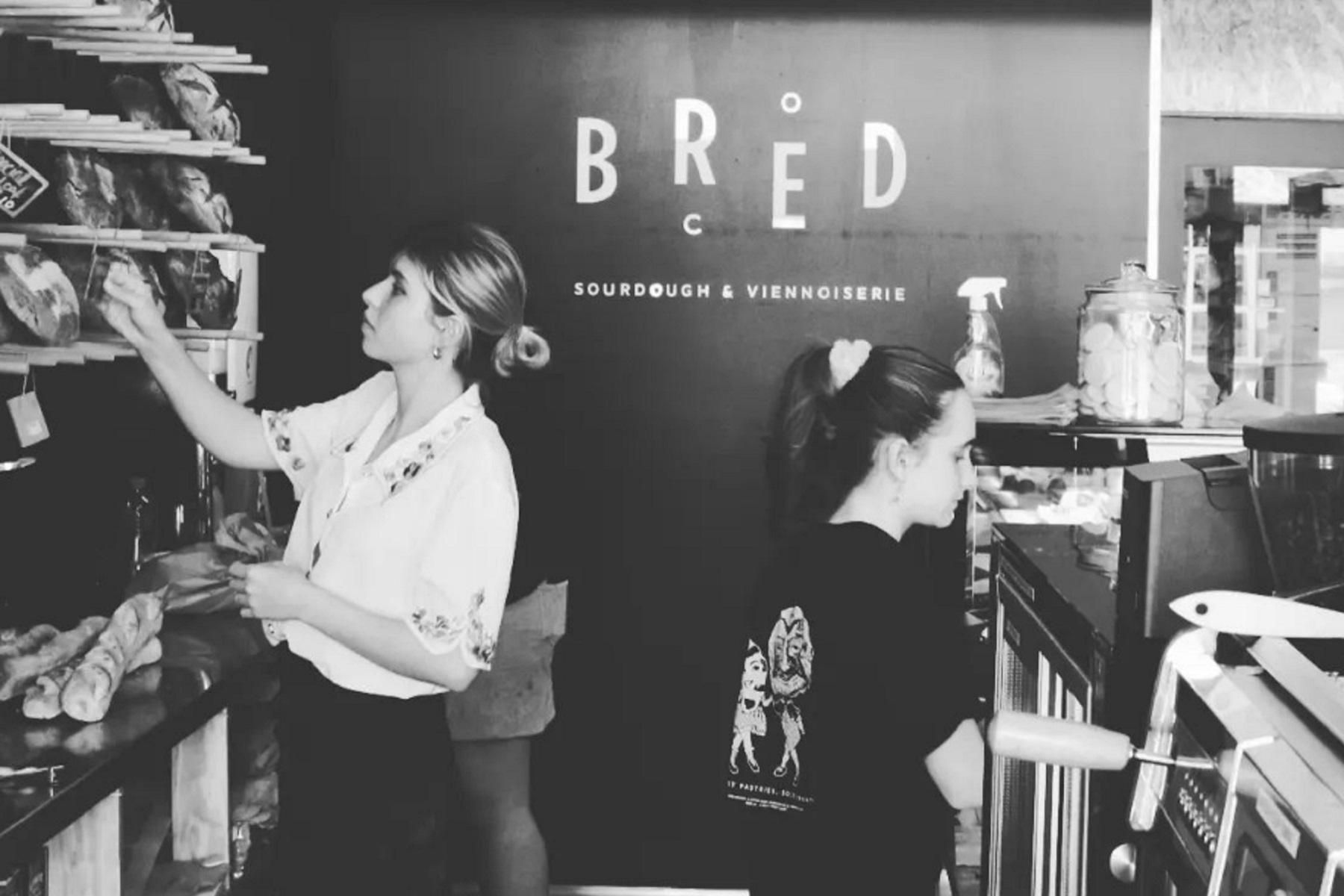 Image of 2 workers behind the counter of a shop