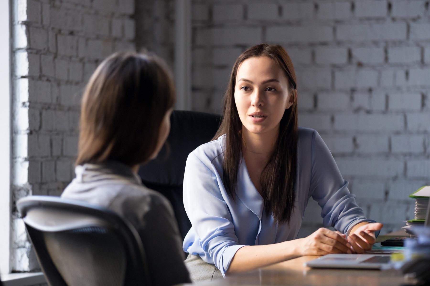 Photo of two women having a discussion in a meeting room.
