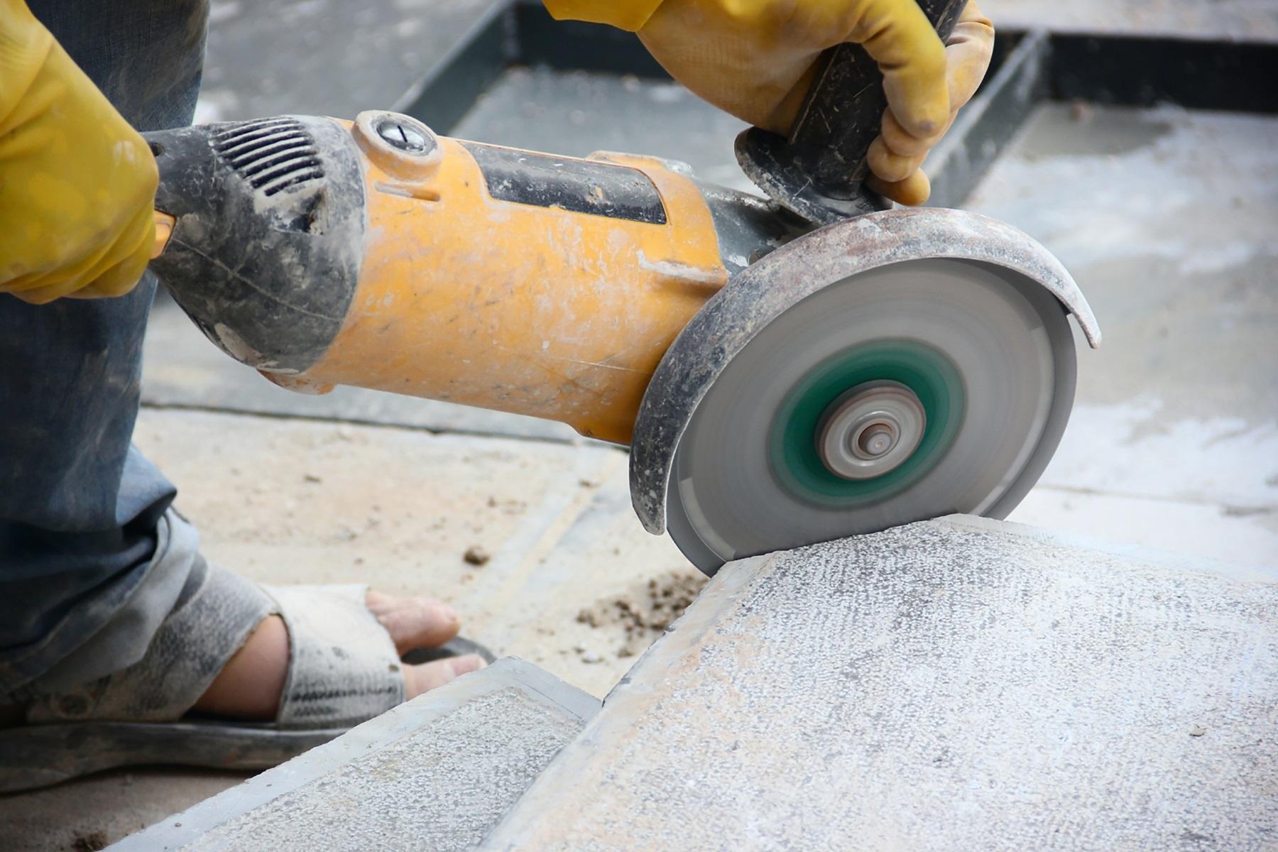 Photo of an angle grinder cutting a piece of stone.