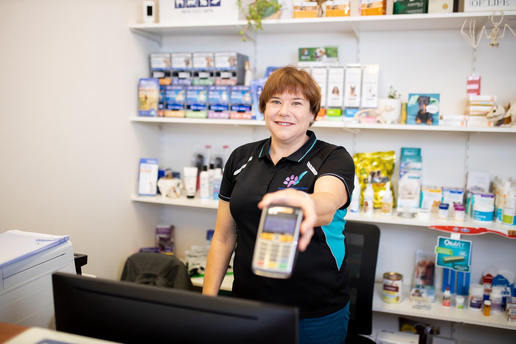 Photo of a female small business owner holding an EFTPOS terminal.