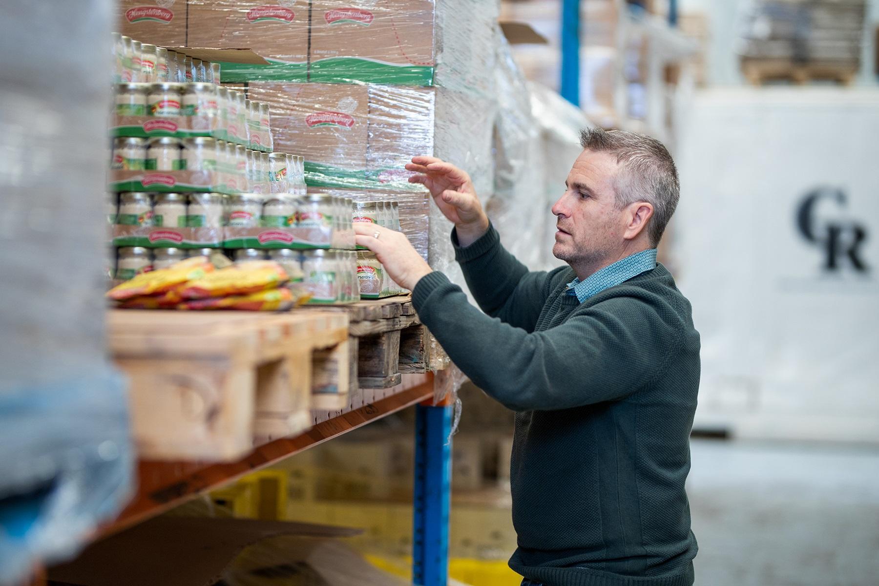 Photo of a man in a warehouse checking inventory.