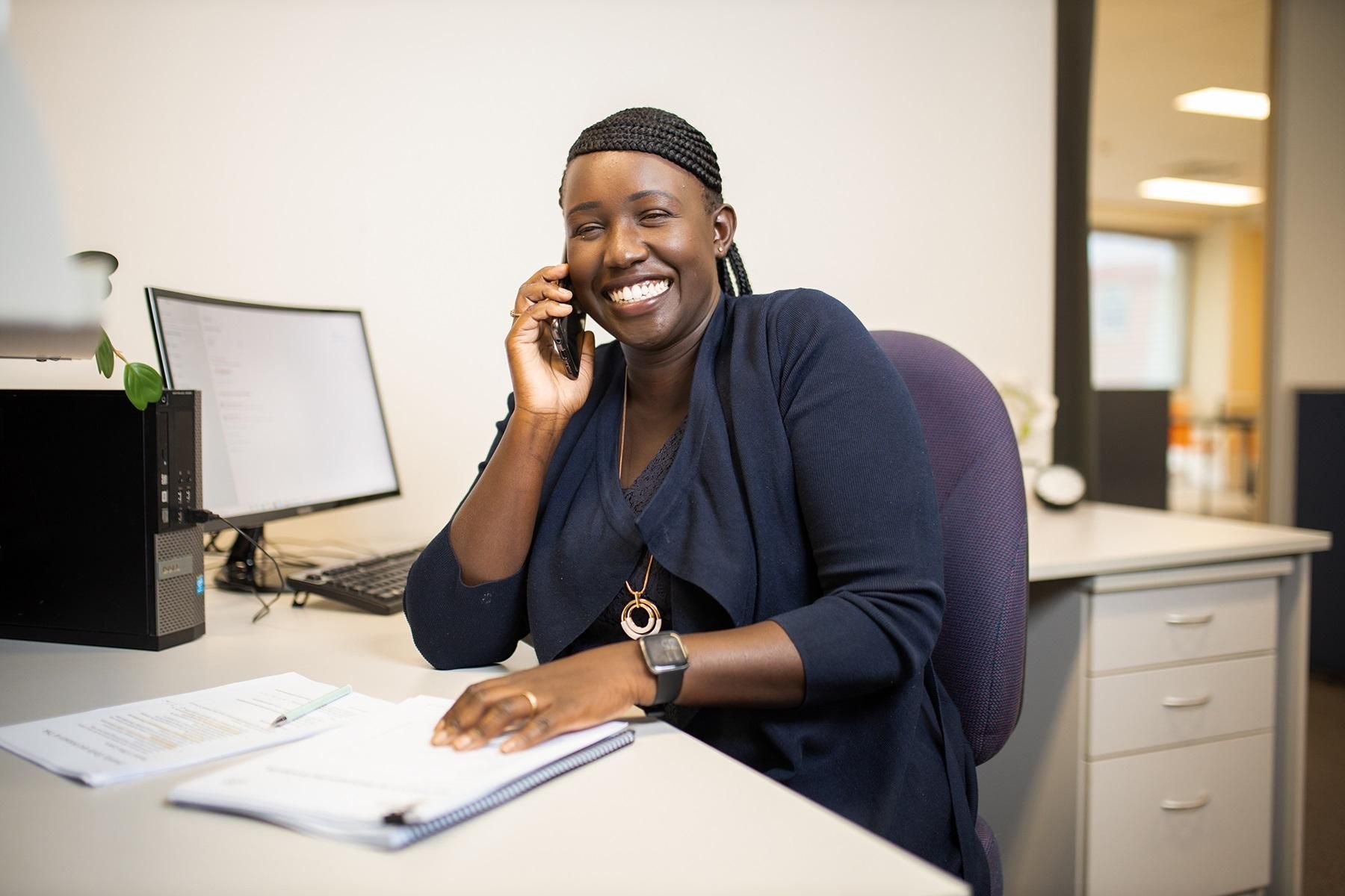 Photo of Elizabeth Lang, owner of Diversity Focus. She is sitting at her desk while speaking on the telephone.