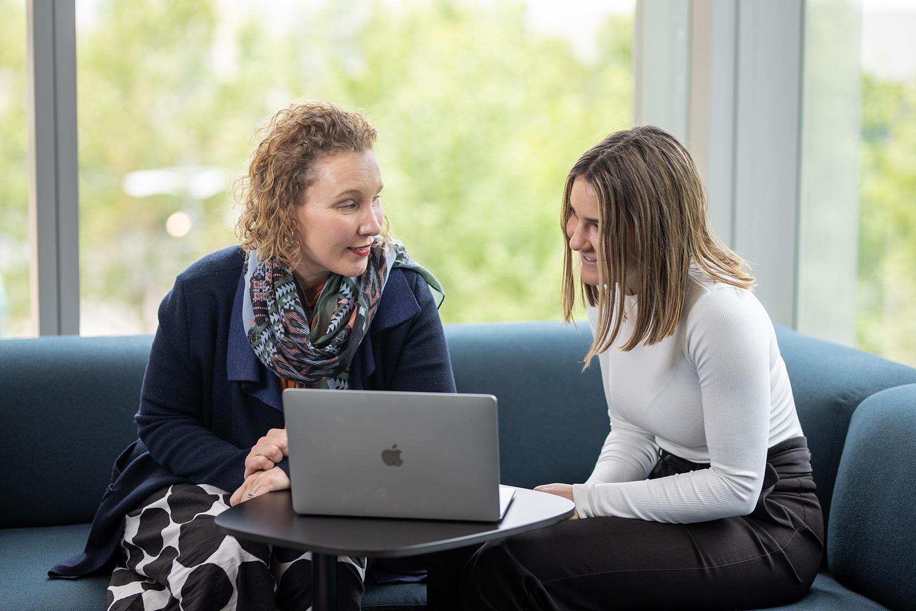 A photo of two women having a conversation.