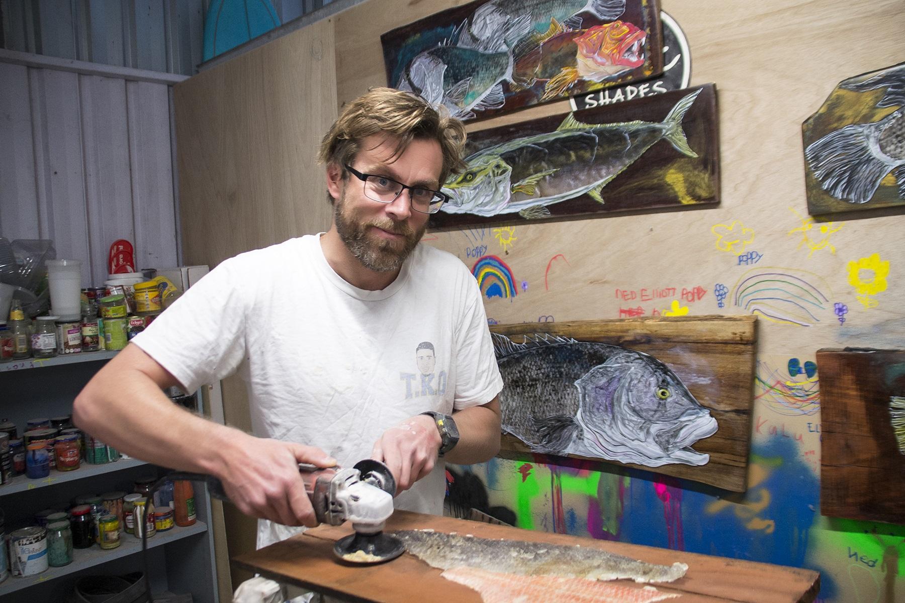 Photo of Pat McCarthy, owner of Pmac Shapes and Fish on Fish Skins, working on a fish skin based artwork.