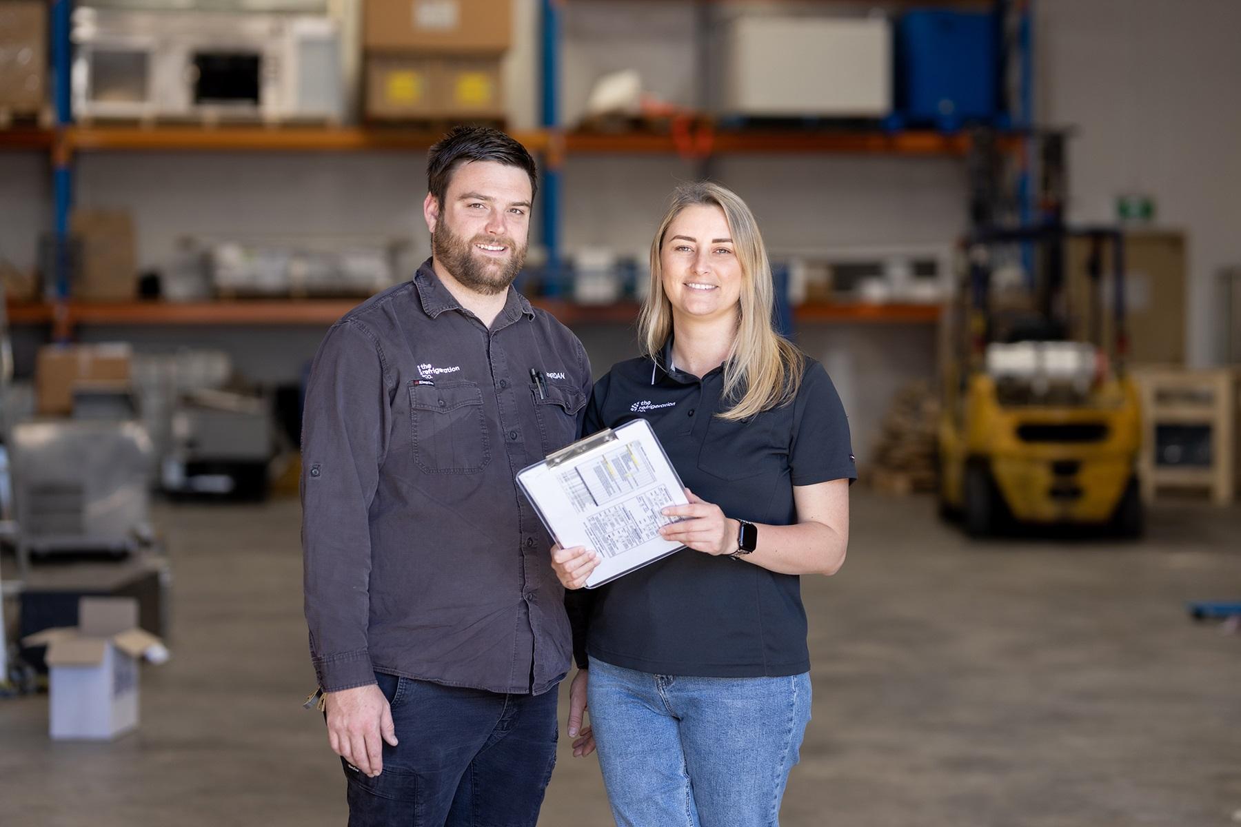 Photo of a male and female business partner standing in their business premises.