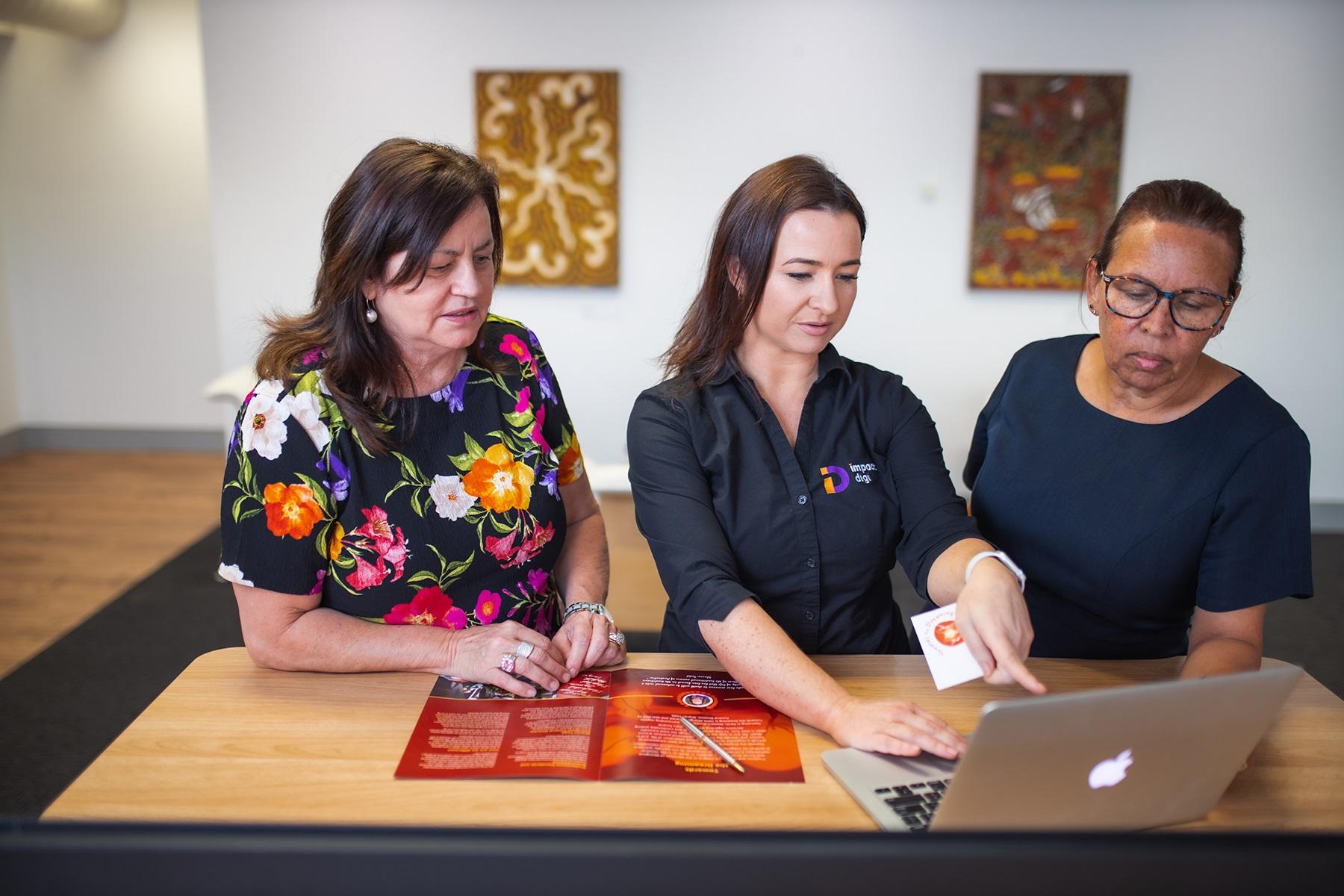 Photo of a female business owner meeting with clients.