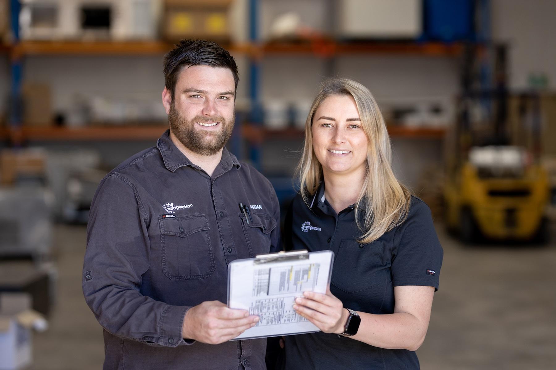 Photo of a male and female business owners standing in their warehouse.