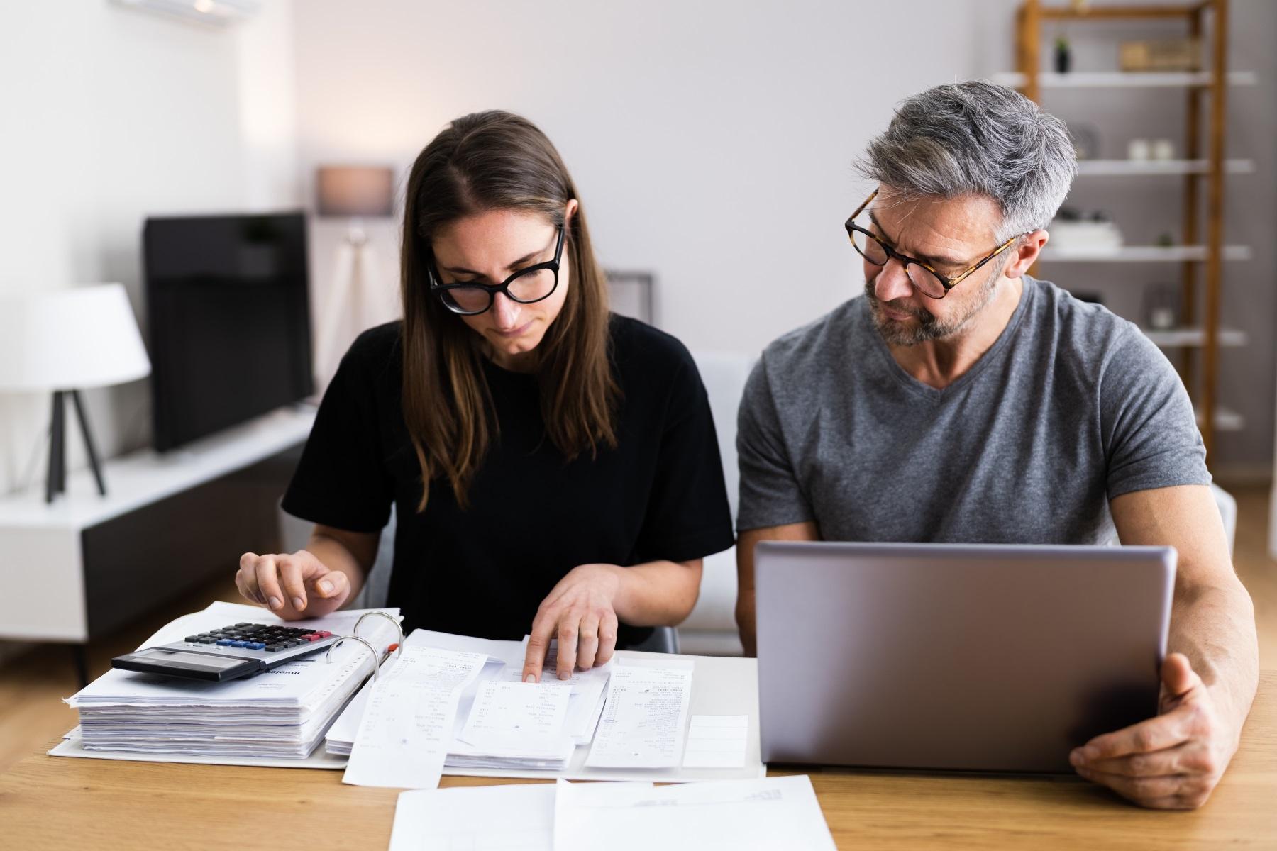 Photo of a man and woman sitting at a table reviewing financial documents.